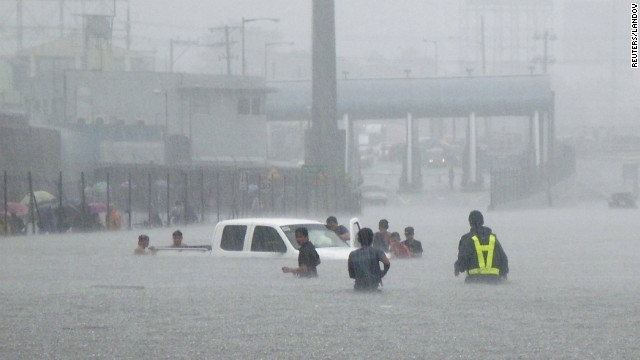 Motorists and passengers are trapped on the North Luzon Expressway as heavy rains continue Tuesday in Valenzuela City.