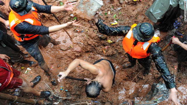 Rescuers dig through the rubble of a landslide caused by flooding as they try to rescue victims in Quezon City in suburban Manila.