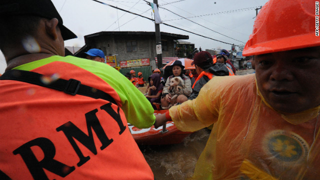 Rescue workers prepare to unload residents in the village of Tumana after their homes were flooded.