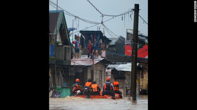 Rescuers in rubber boats evacuate residents from their homes in Tumana. 
