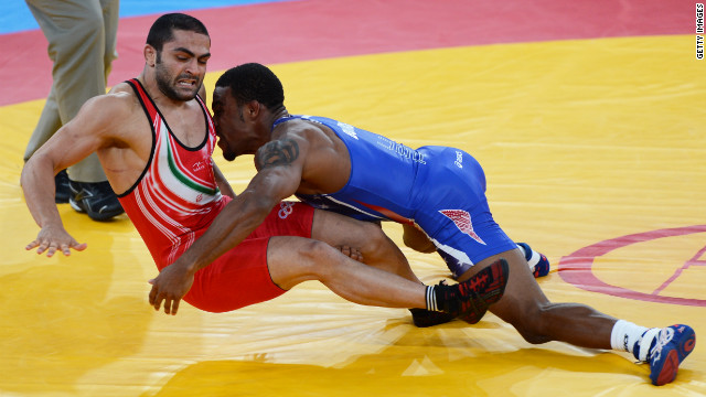 Burroughs, in blue, grapples with Goudarzi in the gold medal match.