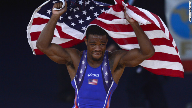 U.S. wrestler Jordan Ernest Burroughs celebrates with the national flag after defeating Iran's Sadegh Saeed Goudarzi in the men's freestyle gold medal match.