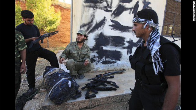 Free Syrian Army members check a confiscated cache of weapons found on a truck that was searched at a checkpoint in Dana.