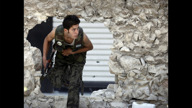  A Free Syrian Army fighter runs for cover during heavy fighting in the Salaheddine neighborhood.