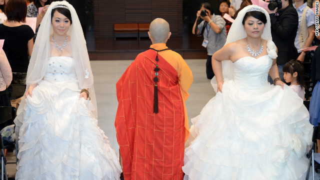 Huang Mei-yu (R) and her partner You Ya-ting attend their Buddhist wedding ceremony in Taoyuan, Taiwan, on Saturday.