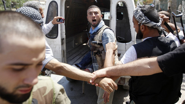 A Free Syrian Army fighter learns that his commander has been killed by a tank shell in Aleppo on Tuesday, August 14. Opposition activists say shelling in dissident strongholds has exacerbated the humanitarian crisis in the country.