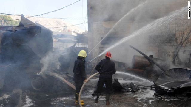 Firefighters work at the scene of a bomb explosion in central Damascus. The bomb was planted under a diesel tanker.