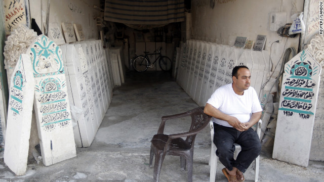  A man sits in front of tombstone workshop in Aleppo.