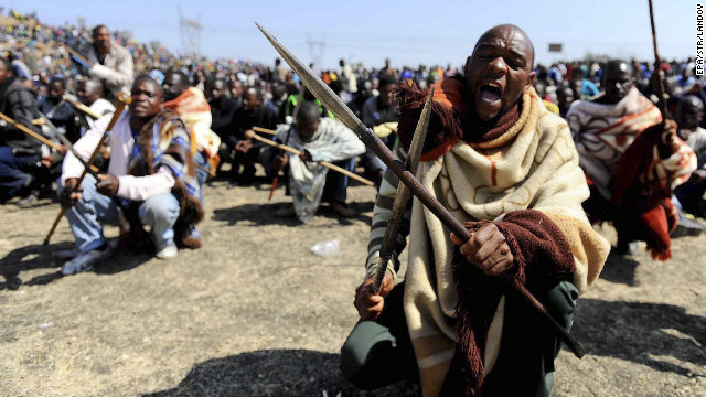 Striking South African miners armed with homemade spears and pangas chant slogans near Marikana platinum mine in Rustenburg, South Africa, on Thursday, August 16. Rising tensions at the mine exploded Thursday in grisly violence as police opened fire on striking miners.