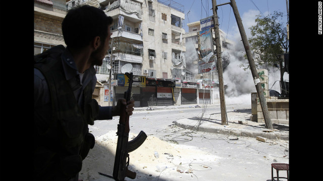 A rebel fighter runs for cover as a Syrian army tank shell hits a nearby building Friday in Aleppo. The opposition accuses Syrian forces of shelling flashpoint neighborhoods in Aleppo where rebels are making a stand. 