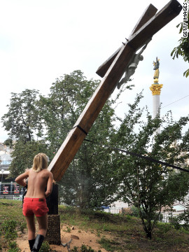 The court case has sparked demonstrations of support across Europe and the U.S. An activist from feminist group Femen cuts down an Orthodox cross in Ukraine, erected in memory of victims of political oppression, in a show of solidarity with the punk band.