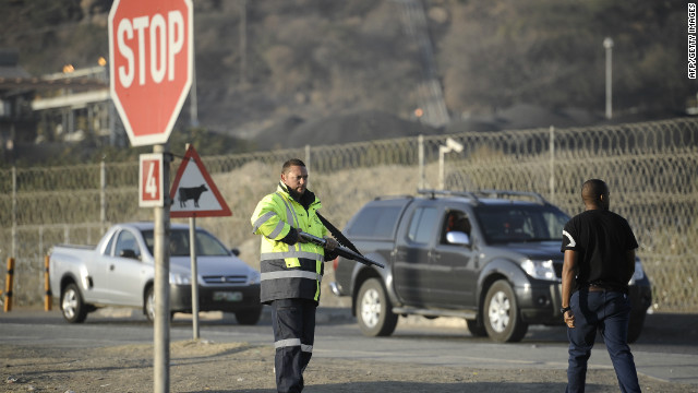 A private security guard mans the entrance to the Marikana platinum mine on August 21 where five days earlier police opened fire on striking workers. The violence left 34 dead.