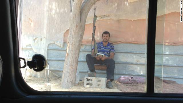 A Hamas security guard reads the Quran at the entrance to one of the smuggling tunnels.