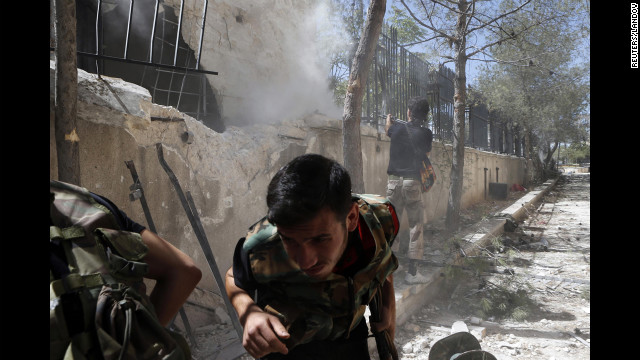 A Syrian rebel fires towards a pro-government sniper in the Said al-Dawla district of Aleppo on August 22.