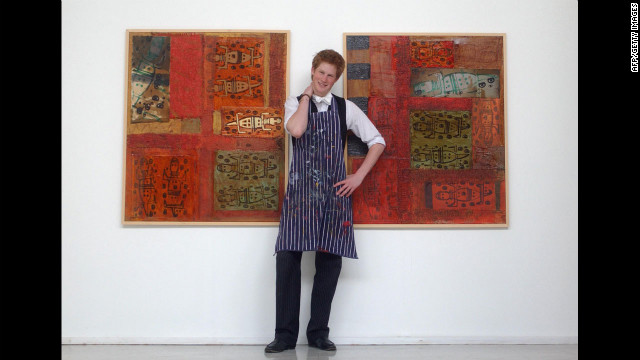 Prince Harry stands in the Drawing School on May 12, 2003, between two of the works he completed while studying at Eton College. His work involves a mixture of painting and printing, and reflects his habit of using animals as his starting point.