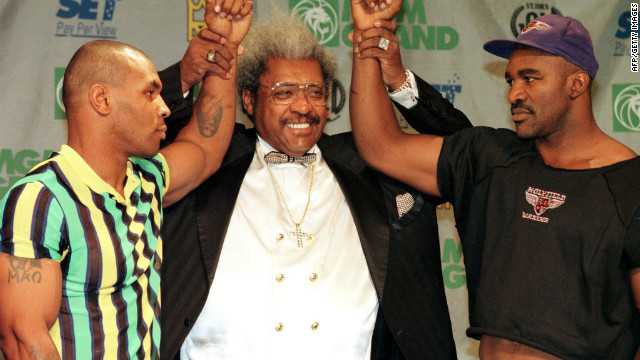 King poses with heavyweight champion Evander Holyfield, right, and challenger Mike Tyson before a 1997 rematch. During the fight, Tyson famously bit off part of Holyfield's ear.