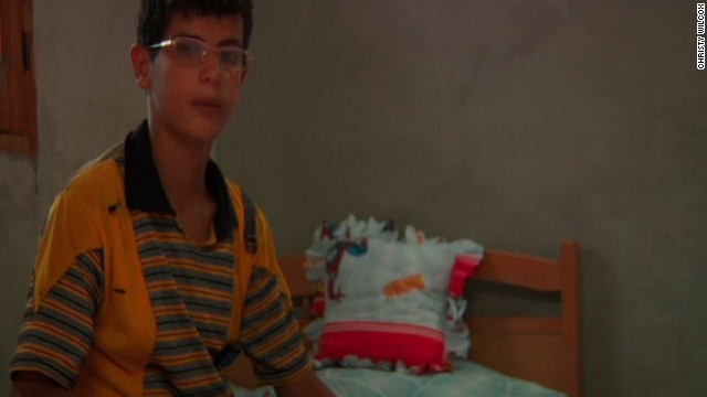 Jihad Mansour sits on his Spiderman bed in the room he used to share with his brother, who was killed on his way to school.