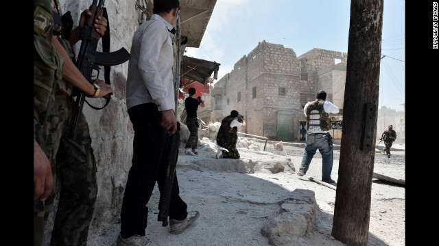 Rebel fighters fire in the streets against pro-Syrian government forces.
