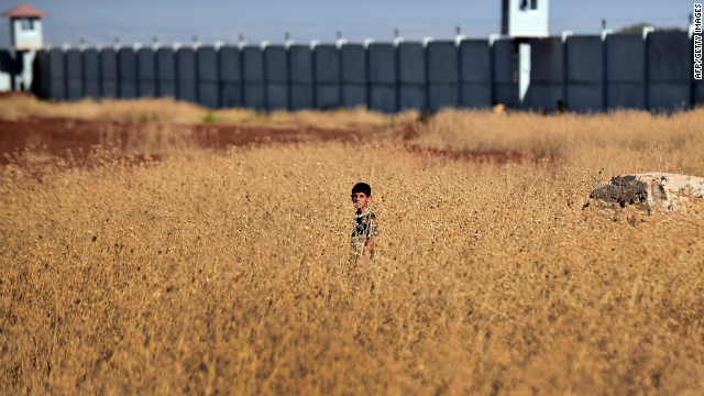 A Syrian boy whose family has been displaced due to fighting between rebel fighters and Syrian government forces stands in a field near the border with Turkey.