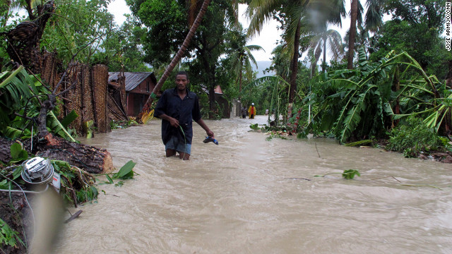 Residents of Jacmel, Haiti, make their way through floodwaters as Tropical Storm Isaac dumps heavy rains in August 2012. An extreme exposure to climate-related events, combined with poor health care access, weak infrastructure, high levels of poverty and an over-reliance on agriculture have led to the country being categorized as at "extreme" risk.