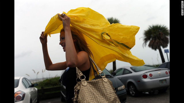 Rachel Bolch Thach tries to shelter herself from the rain in Tampa. Tropical Storm Isaac is expected to bring rain and wind to the area and has caused convention officials to delay the start of the convention until Tuesday.