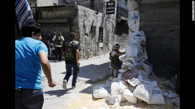 Free Syrian Army fighters run for cover in the old city of Aleppo on Monday. 