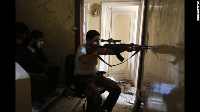 A Free Syrian Army sniper takes his position in Seif El Dawla on Monday.