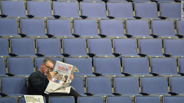 A man reads a newspaper in the empty seats of the Tampa Bay Times Forum.