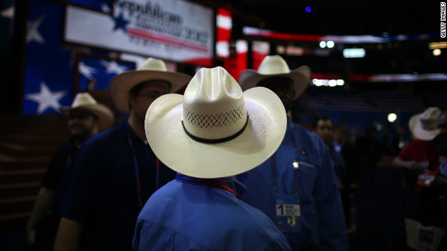 Men wearing cowboy hats stand on the arena floor before the start of the abbreviated first day.