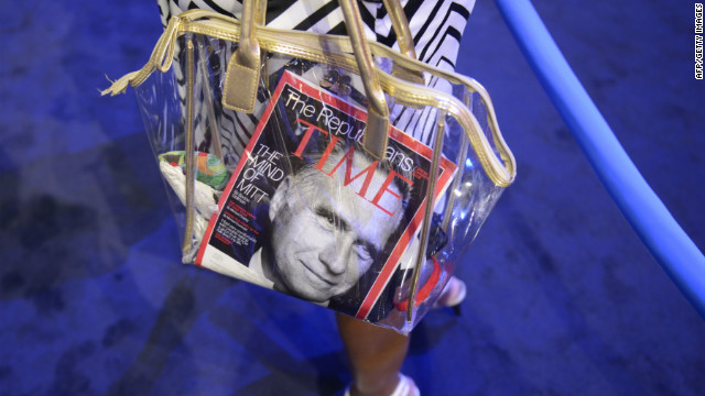 A convention attendee carries a bag with a Time magazine featuring Mitt Romney on the cover.