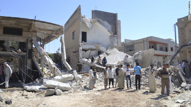 Residents walk past buildings damaged in what activists said was an airstrike by the Syrian air force on Kafranbel, near Idlib.