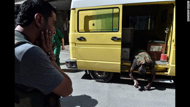 A man reacts as an ambulance arrives with the body of a Free Syrian Army fighter outside a hospital in Aleppo.