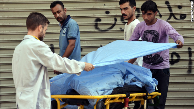 A paramedic and another man cover the body of a Free Syrian Army fighter outside a hospital in Aleppo.