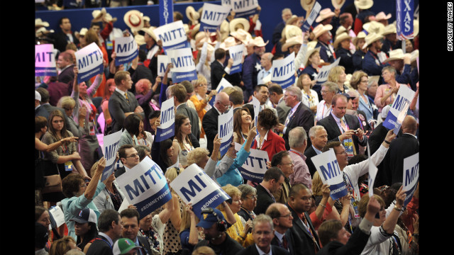 Delegates display signs in support of Mitt Romney after the tallying of votes during the roll call for nomination of president of the United States.