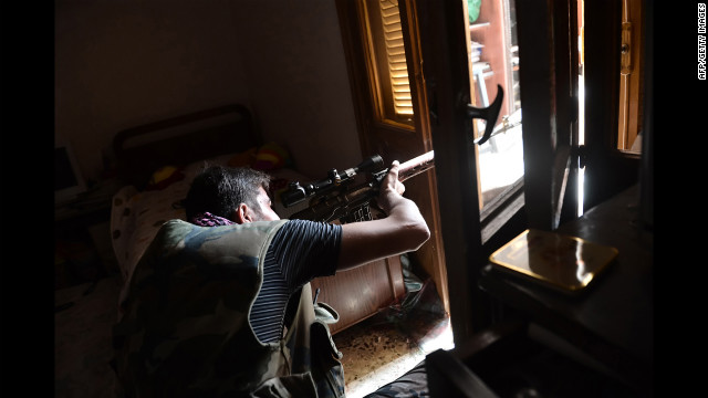 A Syrian opposition fighter aims a sniper rifle at government forces in Aleppo on Wednesday, August 29.