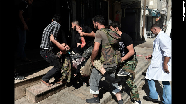 Free Syrian Army fighters carry a wounded member into a hospital in Aleppo on Tuesday, August 28.