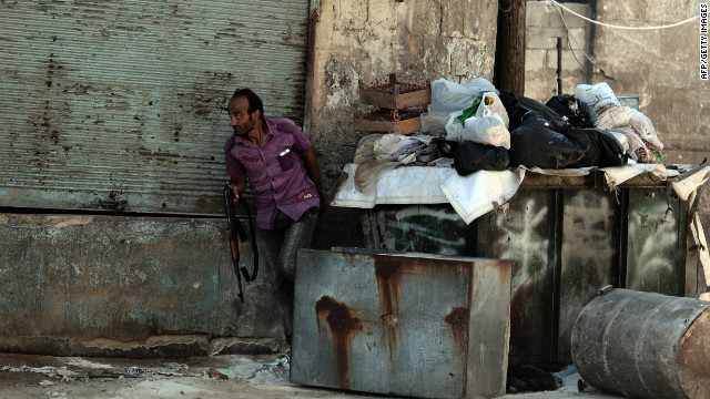 A rebel fighter takes cover during clashes Tuesday with government forces in Aleppo.