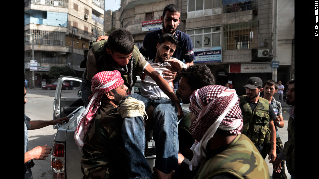 Members of the Syrian opposition carry a wounded man outside a hospital in Aleppo on Thursday, August 30. 