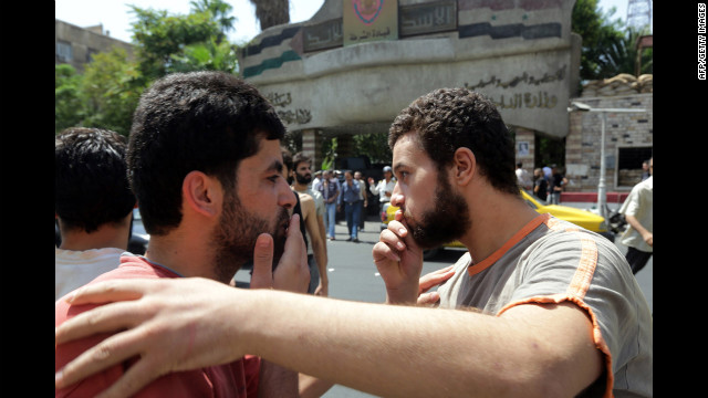 Syrian prisoners congratulate each other as they walk out of the Damascus central police station.