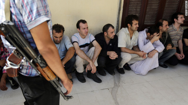 Syrian prisoners wait in line to sign their release papers at the Damascus central police station on Saturday, as the authorities released 158 people from the facility.
