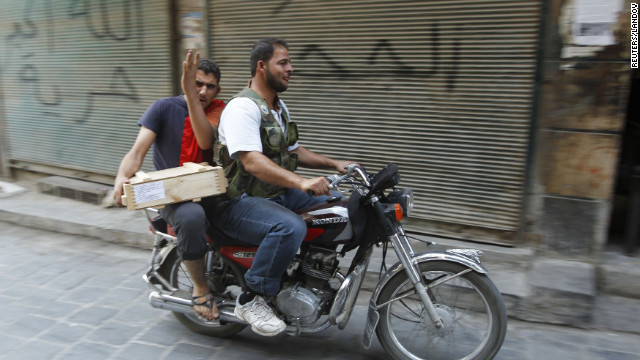 Free Syrian Army fighters transport explosives on a motorbike in Aleppo on Friday, August 31.