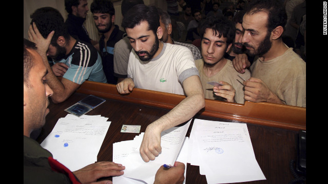 Syrian detainees who were arrested for participation in protests against Syrian President Bashar al-Assad's regime sign their release papers at the Damascus police leadership building Saturday, September 1.