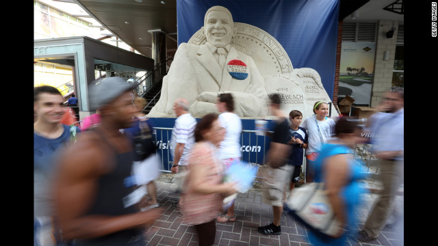 People walk past a sand sculpture of Obama along the streets of Charlotte ahead of the Democratic convention on Monday.