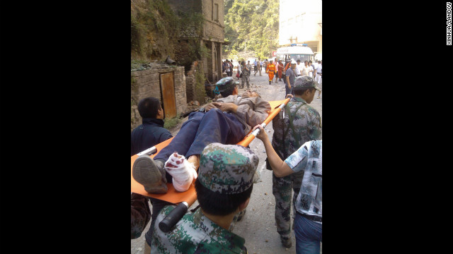  An injured villager is carried on a stretcher by rescuers in Luozehe Town, Yunnan province.