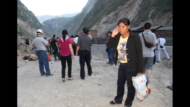 A woman cries while she makes a phone call on a blocked road in Yiliang, Yunnan province.