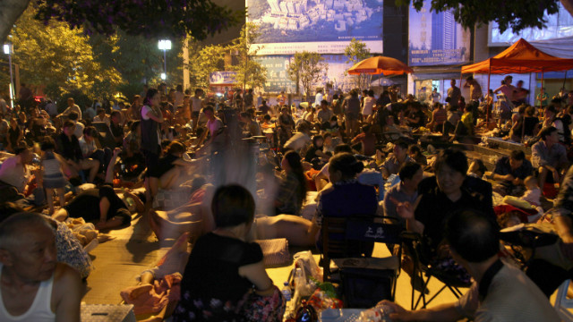 Residents gather to spend a night in the open at the town square in Yiliang.