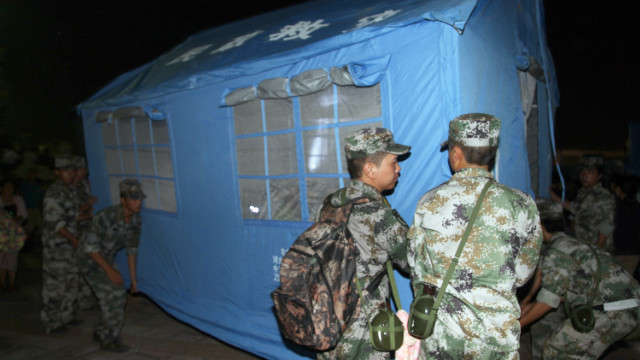 Rescuers set up a tent at an emergency relief center in Yiliang.