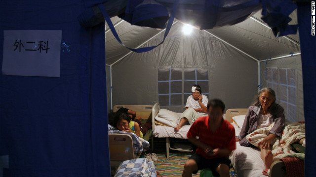 Injured residents rest in a makeshift medical tent after being attended to at an emergency relief center set up in the town square in Yiliang on September 8. Two shallow 5.6-magnitude quakes hit mountainous southwestern China, killing at least 80 people and forcing tens of thousands to leave damaged buildings, state media said.