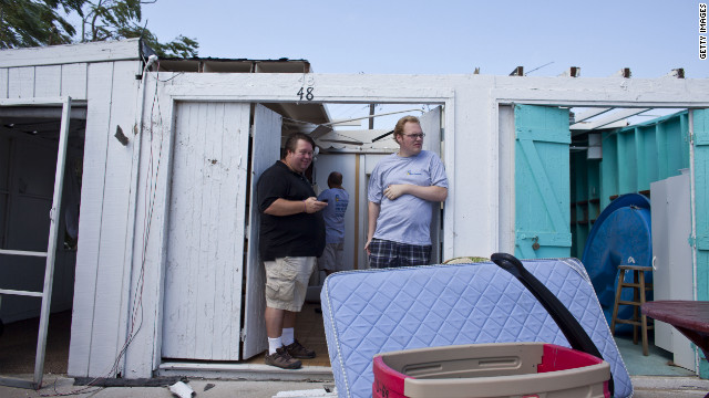  People inspect the damage in their rental cabanas.