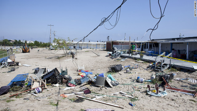 People's personal items are strewn on the sand.